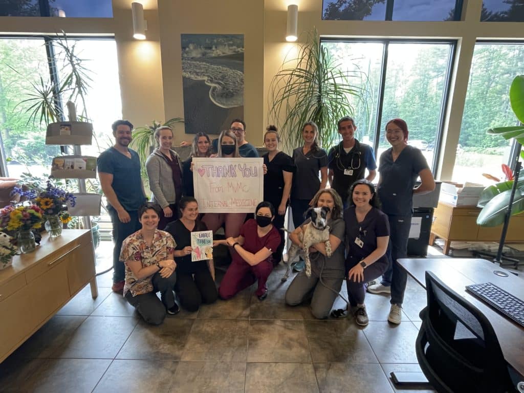 After horrific cyberbullying, the MVMC team smiles holding a thank you sign in light of the support received from the greater community.