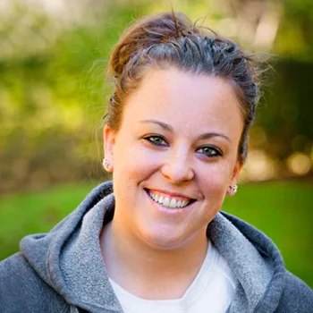 A smiling veterinarian outside.